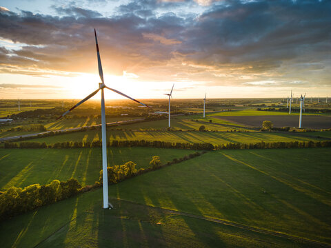Aerial View of Windturbine against sunset with moody golden lighting