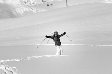 Happy girl on off-piste slope with new fallen snow at nice winter day. Black and white.
