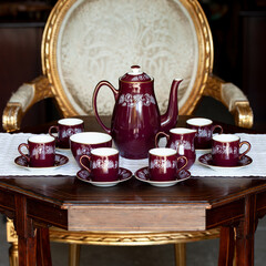 antique dark red porcelain service with national painting. service in the Ukrainian style in a luxury interior. ceramics close-up