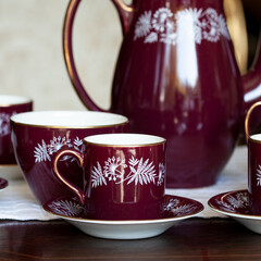 antique dark red porcelain service with national painting. service in the Ukrainian style in a luxury interior. ceramics close-up