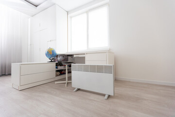 Modern electric heater in stylish room interior.