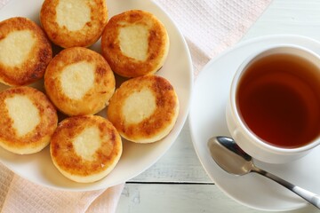 curd fritters with tea. Traditional breakfast. Food on a bright table.