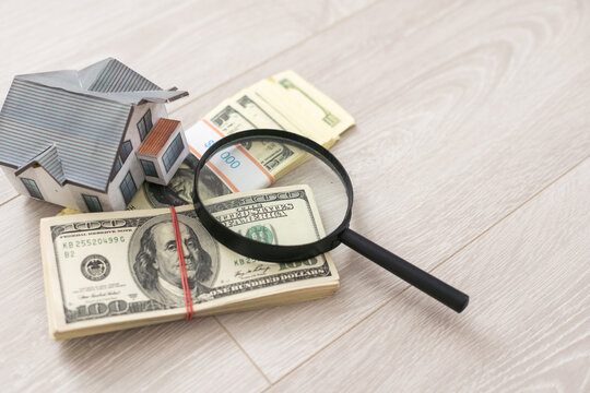 dollar, toy house next to a magnifying glass, sale of real estate, rental housing - Powered by Adobe