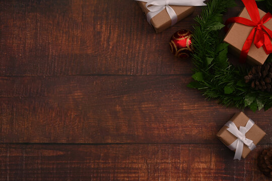 Flat lay Christmas gifts boxes, fir tree branches and pine cones on wooden background. Christmas background concept