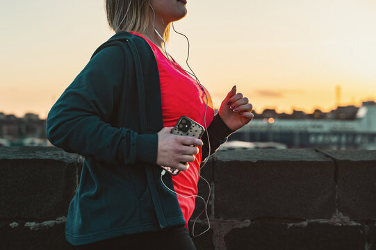 Active Young Curvy Woman Exercising Running Outdoors At Sunset