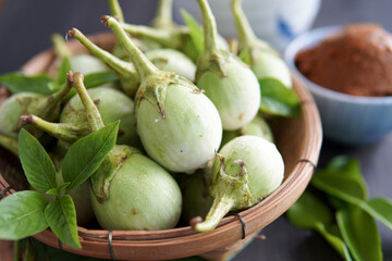 eggplants and sweet basil in a bamboo basket.