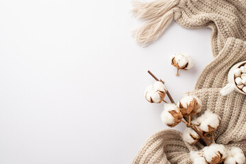 Winter season aesthetic. Top view photo of knitted plaid cup of hot drinking with marshmallow and cotton branch on isolated white background with copyspace