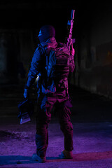 Army soldier in Combat Uniforms with an assault rifle and combat helmet night mission dark...