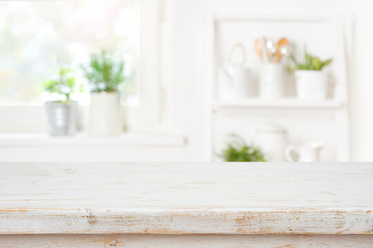 Rustic kitchen table top in front of blurred interior background
