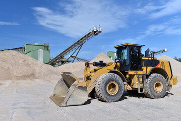 heavy construction machine in open-cast mining - wheel loader transports gravel in a gravel plant