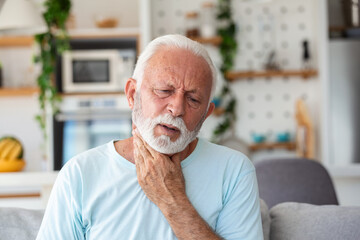 Close up of senior man rubbing his inflamed tonsils, tonsilitis problem, cropped. Man with thyroid...