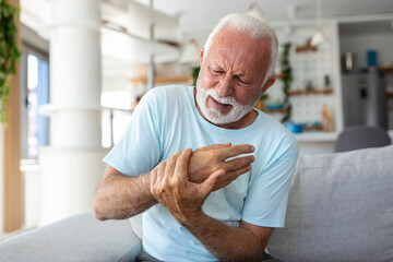 Elderly man has pain in fingers and hands. Old man with finger pain, Man massaging his arthritic...