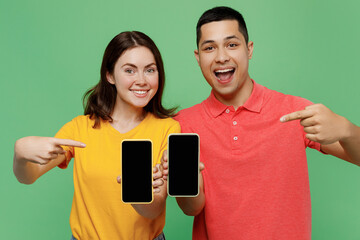 Young couple two friends family man woman in basic t-shirt together hold use point index finger on...