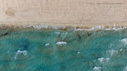 Aerial drone top view to the beach with white sand and blue sea. Luxury summer vacation and resort concept.
