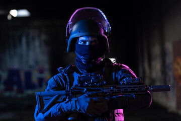 Army soldier in Combat Uniforms with an assault rifle and combat helmet night mission dark...