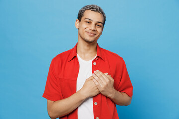 Young smiling happy cheerful satisfied man of African American ethnicity 20s he wear red shirt put...