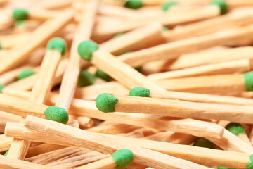 Close-up of a green match head against the background of randomly scattered matches