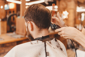 Barbershop vintage color. Man in barber chair, hairdresser master working with clipper and comb