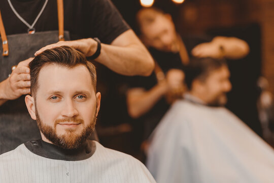 Portrait smile client man in barber chair, hairdresser styling hair. Concept barbershop, vintage color
