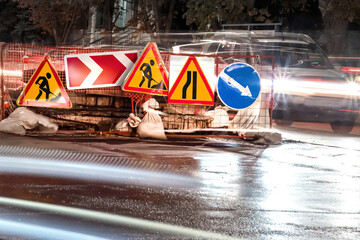 Road closure and diversion signs. Roadworks in night city street