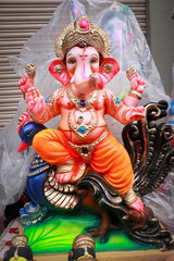 Fototapeta premium A Vibrant colored idol of Lord Ganesh sitting majestically during the Ganesh Chaturthi festival in India. 