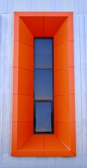 vertical orange window and frame. Building exterior.Facede