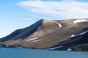 Spectacular panorama view of Wilhelmoya island with mountain range and blue sky. Torellneset,...