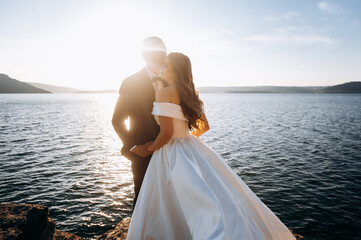 Fototapeta na wymiar Bride and groom, newlyweds, honeymoon on the beach sunset sun