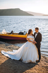 Married couple, bride and groom, embracing at sunset on a beautiful tropical beach