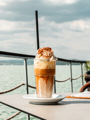 A glass of coffee and ice cream with whipped cream and cocoa at the lake Balaton.