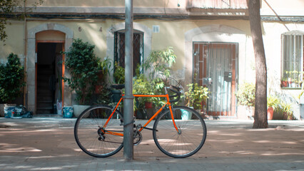 orange bike parked with lock in the city. hipster concept.barcelona