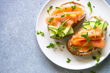 Open sandwich with cream cheese, salmon and cucumber. Healthy breakfast or snack. Top view with copy space.
