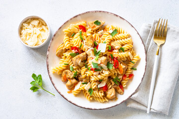 Pasta with turkey or chicken, vegetables and parmesan. Top view at white.