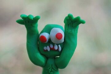 The zombie figurine is trying to scare. Funny monster made of plasticine.