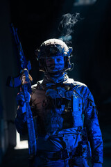 Army soldier in Combat Uniforms with an assault rifle and combat helmet night mission dark...