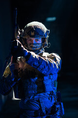 Army soldier in Combat Uniforms with an assault rifle and combat helmet night mission dark...
