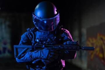 Army soldier in Combat Uniforms with an assault rifle and combat helmet night mission dark...