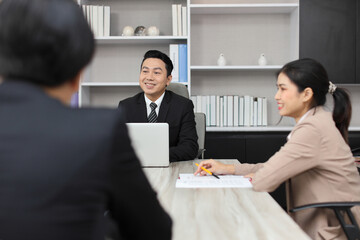 Collaborative process of professional businesspeople going over on new project together, using computer presentation and brainstorming ideas, coworker and working together at office meeting concept