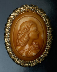 Details of a cameo with a woman and a gold border - obrazy, fototapety, plakaty