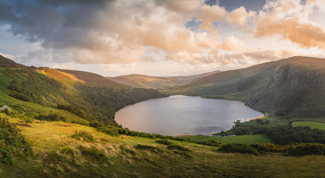 Beautiful panorama with dramatic sunset at Lough Tay, called The Guinness Lake located in deep valley and surrounded by Wicklow Mountains, Ireland