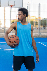 Portrait of a serious basketball player holding ball looking to a side