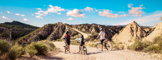 Naklejka premium family mountain bike in desertic landscape