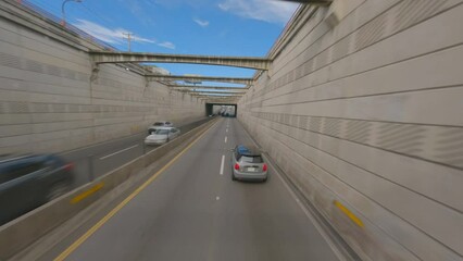 Mini cooper driving along 27 de Febrero avenue  in Santo Domingo city. Aerial tracking drone fpv
