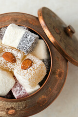 Turkish delight in copper bowl on white background.Close up top view