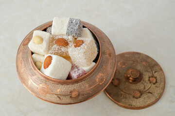 Turkish delight in copper bowl on white background.Close up top view