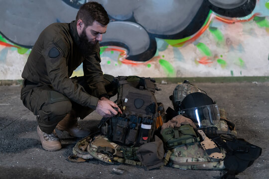 Army body armor, helmet and ammunition, Kalashnikov assault rifle with matrons and first aid tourniquet composition on brown wood. Army body armor. flat laying. military concept.