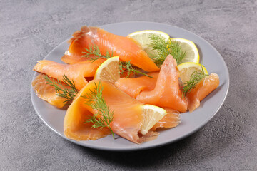 plate of smoked salmon fillet and lemon