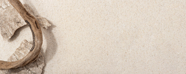 Natural cosmetic background for product presentation. Rocks and driftwood on the sand. Top view.