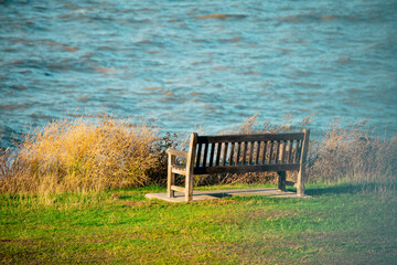 empty lonely wooden bench by the sea in autumn