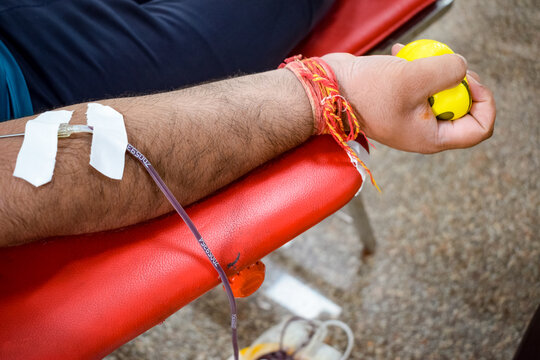Blood donor at Blood donation camp held with a bouncy ball holding in hand at Balaji Temple, Vivek Vihar, Delhi, India, Image for World blood donor day on June 14 every year, Blood Donation Camp